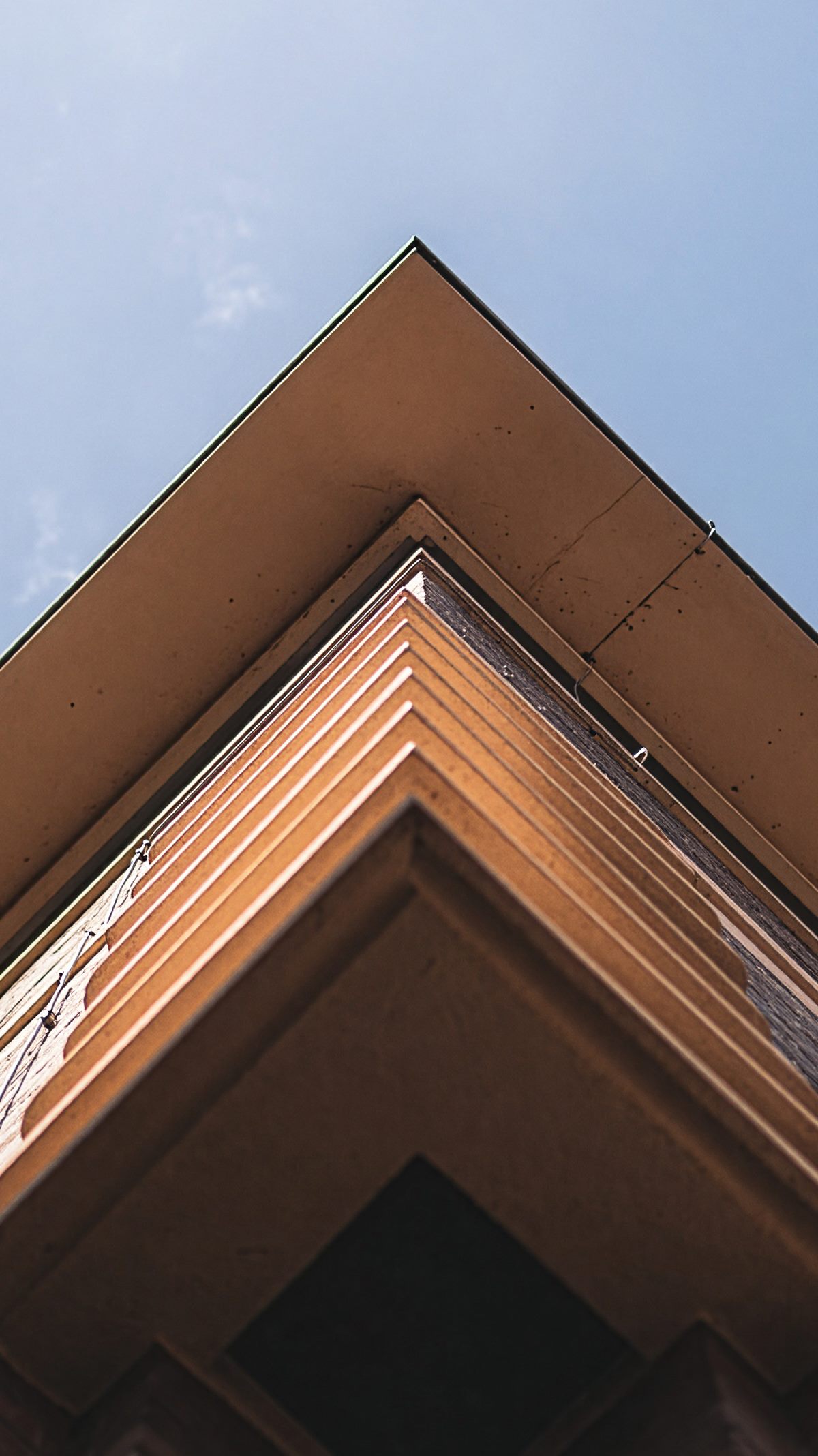 Untersicht auf die gestufte Gebäudeecke der Schäferklinik vor blauem Himmel