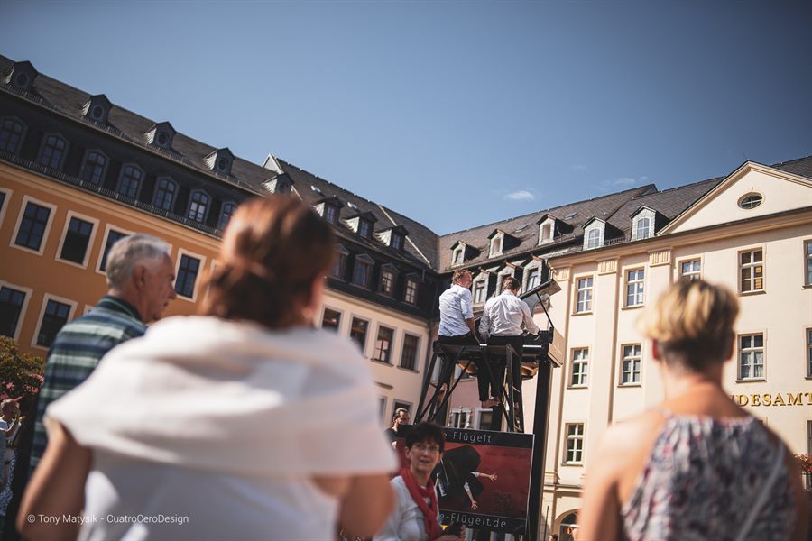 Publikum auf dem Marktplatz Gera beobachtet die Musiker auf dem Bühnengerüst